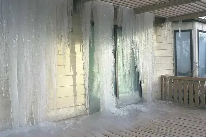 Ice sheeting a porch and outside wall where a frozen pipe split in a hard freeze