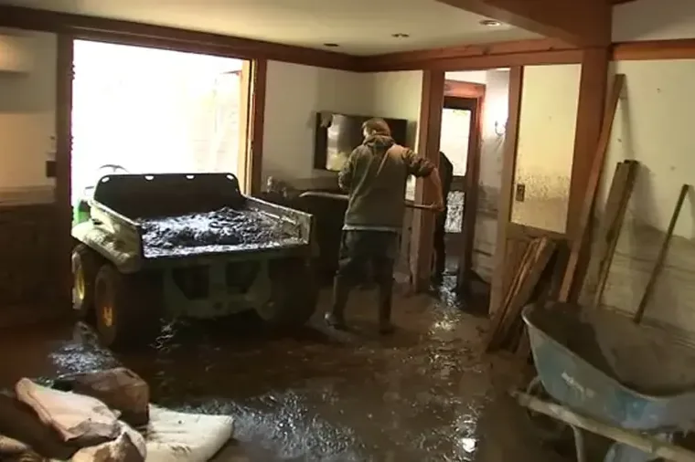 Mud and storm runoff spread across the floor of a lower-level room